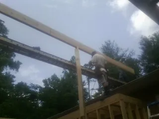 Carpenter setting a ridge beam over a new addition frame — Ice Dam Removal by Roofing Brothers in Braddyville