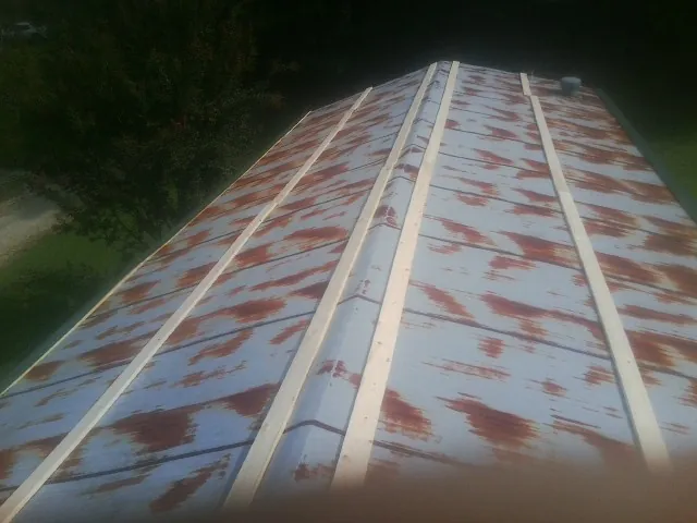 Rusted metal roof panels with new wood purlins before replacement — Storm Damage Roof Repair in Braddyville by Roofing Brothers